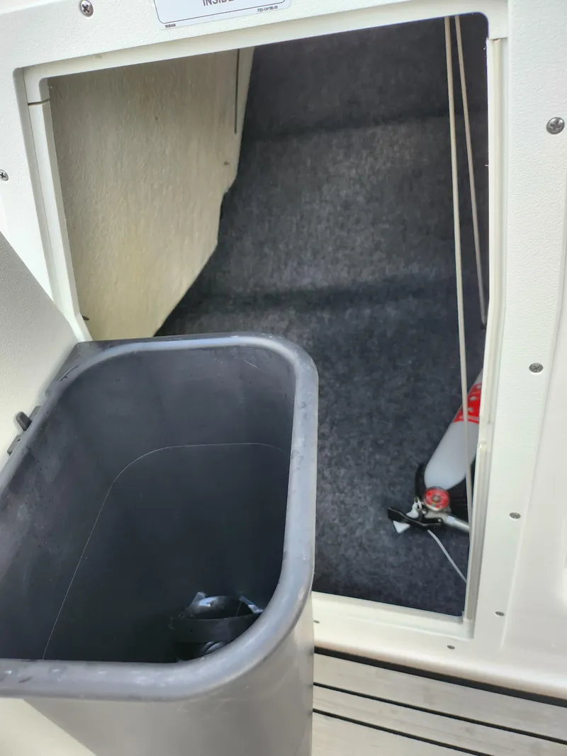 Slide: The Image of 2017 Yamaha Boats AR190 interior storage compartment with a trash bin. - 16