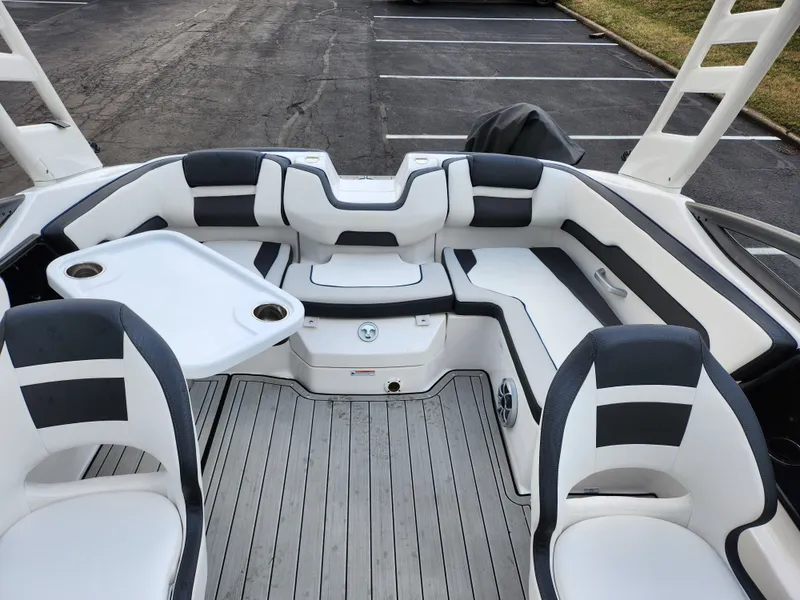 Slide: The Image of 2017 Yamaha Boats AR190 interior with seating and table, parked on asphalt. - 21