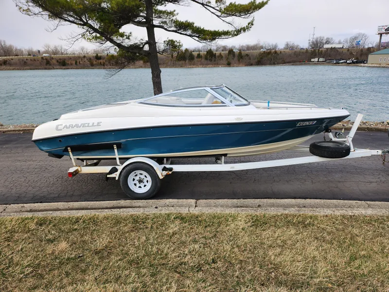 Slide: The Image of 1994 Caravelle 1900 SE boat on trailer by a lakeside road. - 10