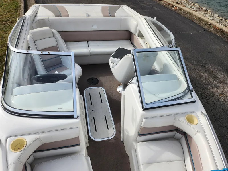 Slide: The Image of 1994 Caravelle 1900 SE boat interior with white and beige seating, open windshield, and waterfront view. - 18