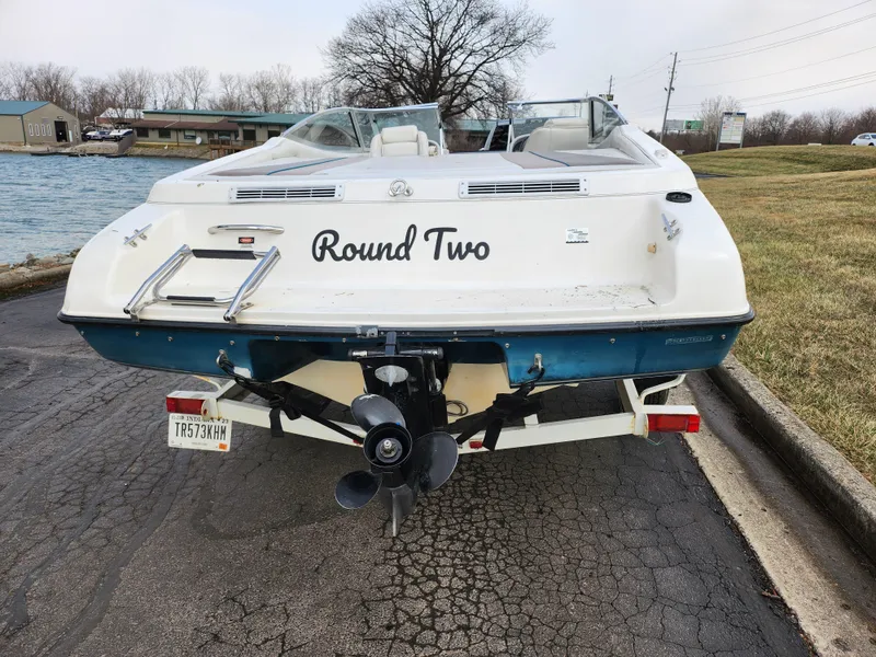 Slide: The Image of Rear view of a 1994 Caravelle 1900 SE boat named "Round Two" on a trailer. - 2