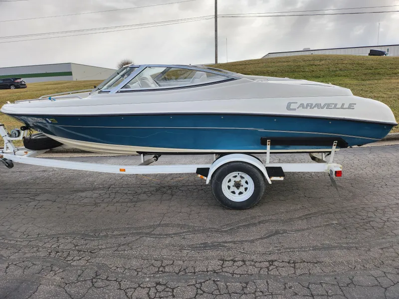 Slide: The Image of 1994 Caravelle 1900 SE boat on trailer, blue and white design, parked on asphalt road. - 4
