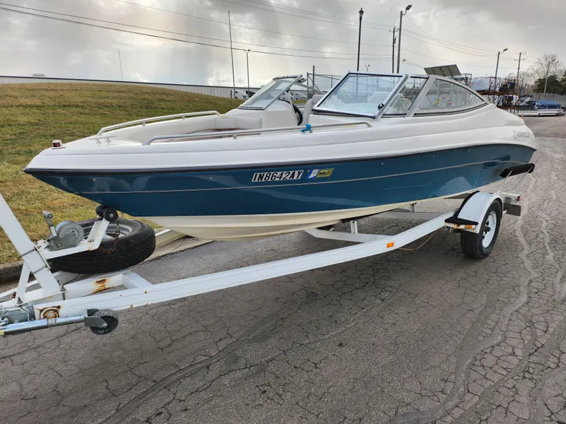 Slide: The Image of 1994 Caravelle 1900 SE boat on trailer, blue and white, parked on a paved road. - 6