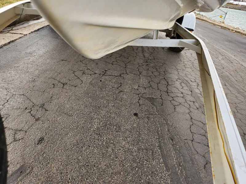 Slide: The Image of Trailer for 1994 Caravelle 1900 SE boat on cracked pavement near water. - 8