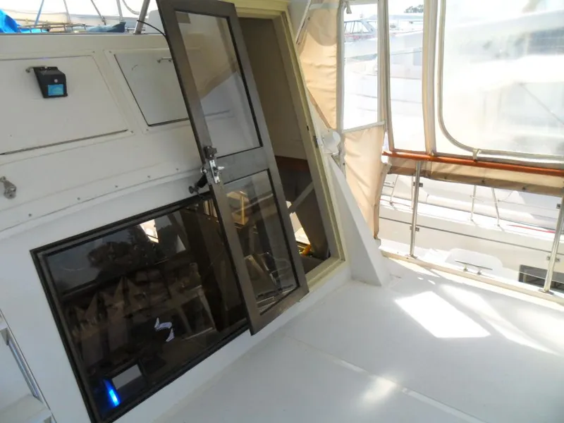 Slide: The Image of 1986 Symbol Yachtfisher interior with open door and bright, spacious deck area. - 10