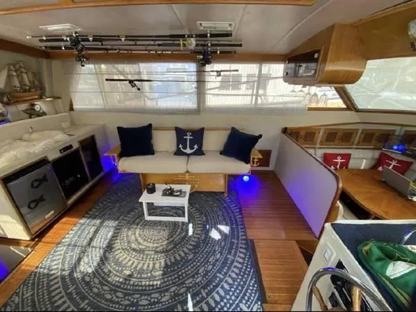 Slide: The Image of Interior of 1986 Symbol Yachtfisher with nautical decor, fishing rods, and cozy seating area. - 11
