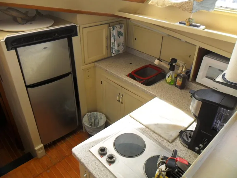 Slide: The Image of Compact kitchen in a 1986 Symbol Yachtfisher, featuring appliances and countertop essentials. - 16