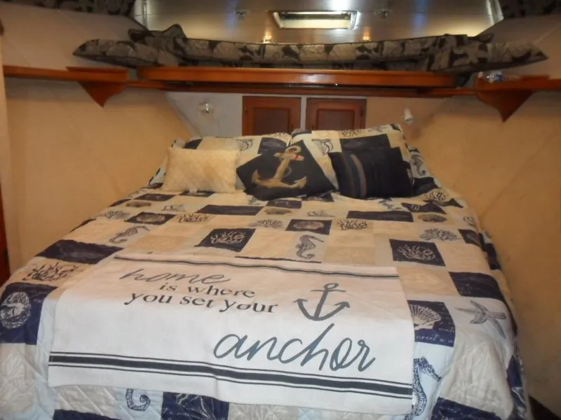Slide: The Image of Cozy yacht bedroom with nautical-themed bedding, featuring anchor designs and decorative pillows. - 18