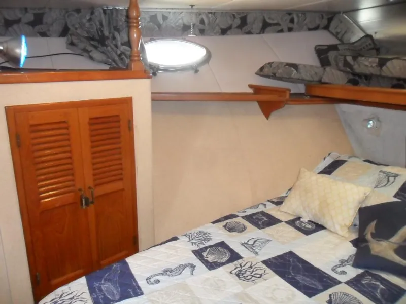 Slide: The Image of Cozy cabin interior of 1986 Symbol Yachtfisher with nautical-themed bedding and wooden storage. - 19