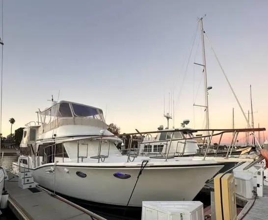 Slide: The Image of 1986 Symbol Yachtfisher docked at sunset, showcasing elegant design and spacious deck. - 2