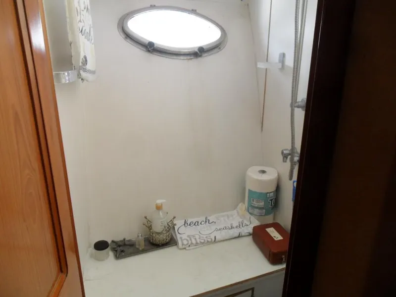 Slide: The Image of 1986 Symbol Yachtfisher bathroom with porthole, toiletries, and towels. - 21
