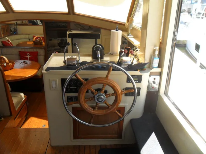 Slide: The Image of 1986 Symbol Yachtfisher helm with wooden steering wheel and nautical interior. - 26