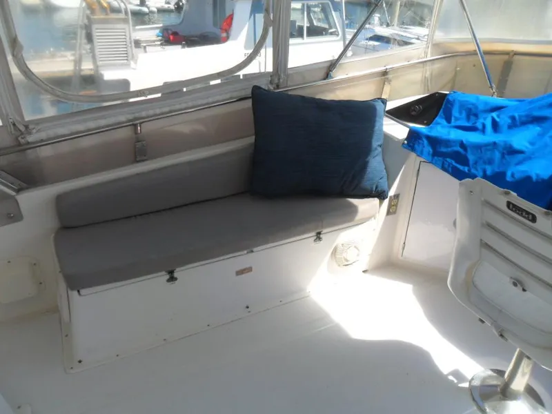 Slide: The Image of 1986 Symbol Yachtfisher interior with cushioned seating and blue pillow. - 33