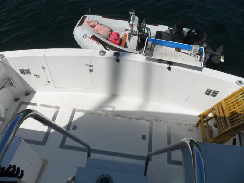 Slide: The Image of 1986 Symbol Yachtfisher deck with dinghy, featuring clean white surfaces and railing. - 35