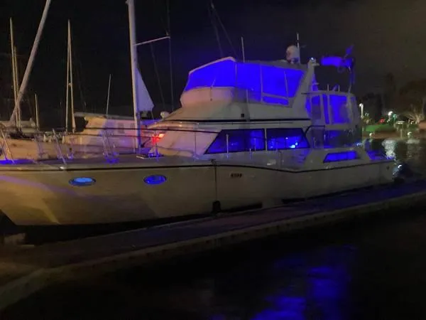 Slide: The Image of 1986 Symbol Yachtfisher illuminated with blue lights at night, docked in a marina. - 44