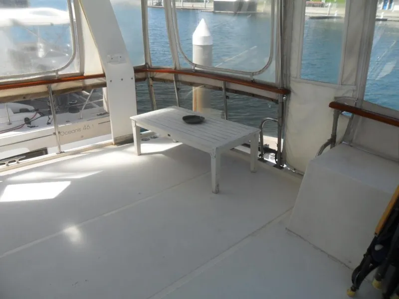 Slide: The Image of 1986 Symbol Yachtfisher interior with white table, overlooking marina. - 7