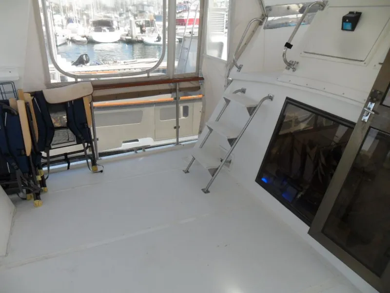 Slide: The Image of 1986 Symbol Yachtfisher interior with seating, ladder, and marina view. - 8