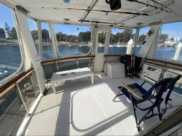 Slide: The Image of 1986 Symbol Yachtfisher interior with seating, fishing gear, and waterfront view. - 9