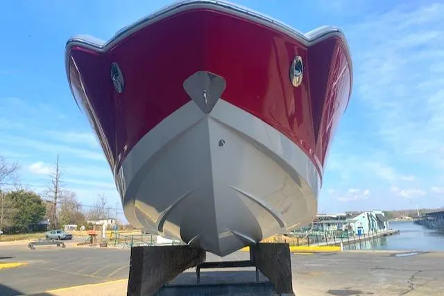 Slide: The Image of 2010 Chaparral Sunesta 224 boat with red hull, docked at marina. - 3
