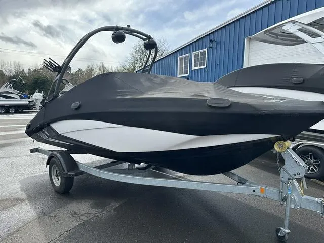 Slide: The Image of 2018 Yamaha Boats AR195 on trailer, covered, parked outside blue building. - 4