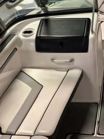 Slide: The Image of Interior seating of 2018 Yamaha Boats AR195, featuring sleek white upholstery and storage compartment. - 9