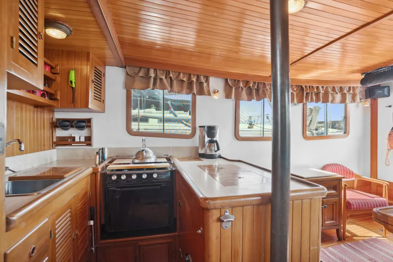 Slide: The Image of Interior of 1987 Lord Nelson 37 Victory Tug with wooden cabinetry and kitchen amenities. - 10