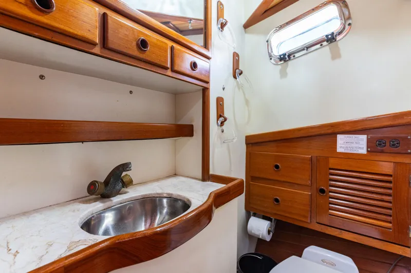 Slide: The Image of 1987 Lord Nelson 37 Victory Tug bathroom with wooden cabinetry and stainless steel sink. - 21