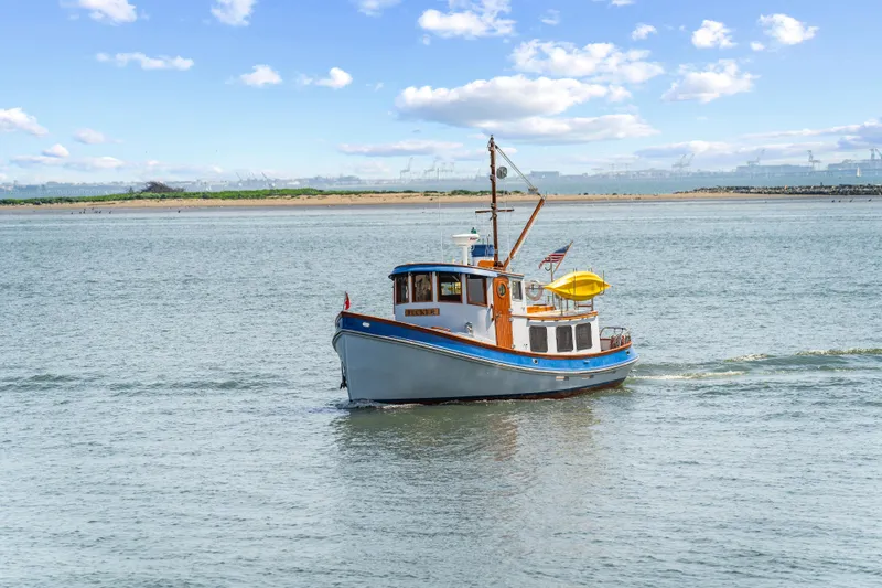 Slide: The Image of 1987 Lord Nelson 37 Victory Tug cruising on a calm, scenic waterway. - 25