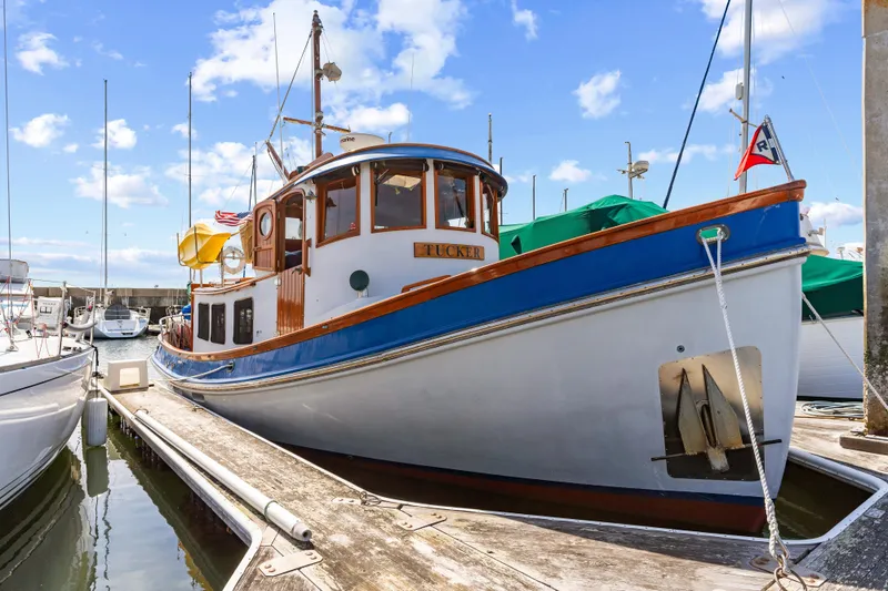 Slide: The Image of 1987 Lord Nelson 37 Victory Tug docked at marina under blue sky. - 3
