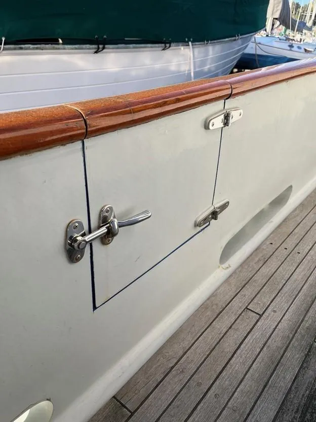 Slide: The Image of 1987 Lord Nelson 37 Victory Tug boat deck with wooden railing and metal latch. - 30