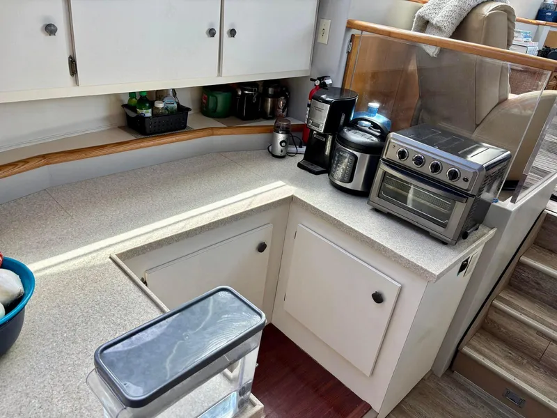 Slide: The Image of 1991 Hatteras 52 Cockpit Motor Yacht kitchen with appliances and storage cabinets. - 15