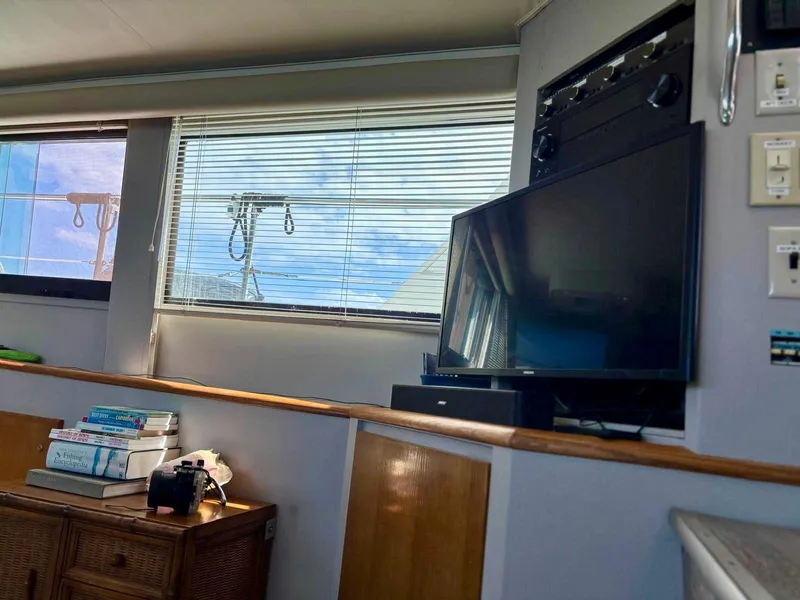 Slide: The Image of Interior of 1991 Hatteras 52 Cockpit Motor Yacht with TV, books, and camera. - 16