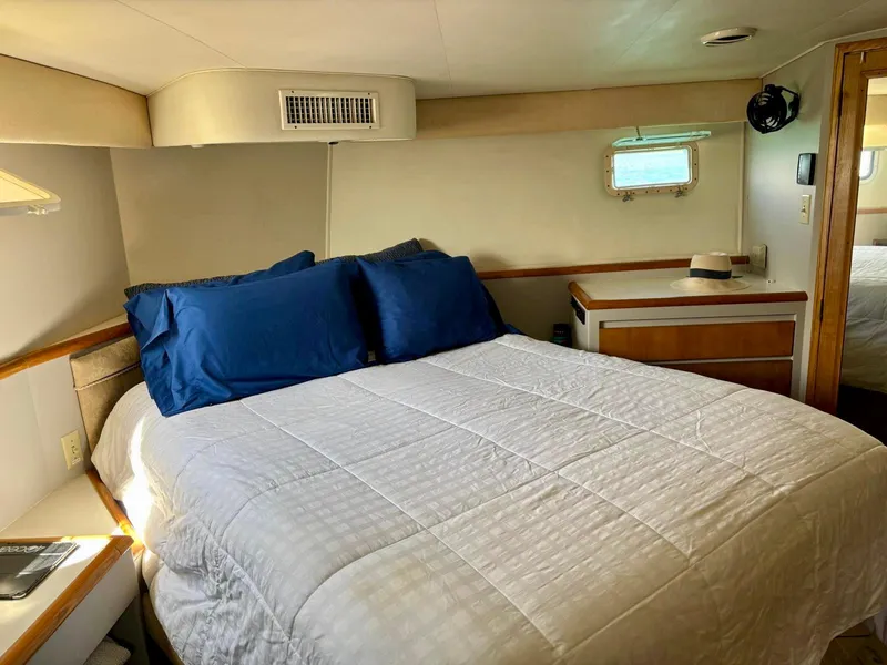 Slide: The Image of Bedroom interior of 1991 Hatteras 52 Cockpit Motor Yacht with cozy bed and blue pillows. - 21