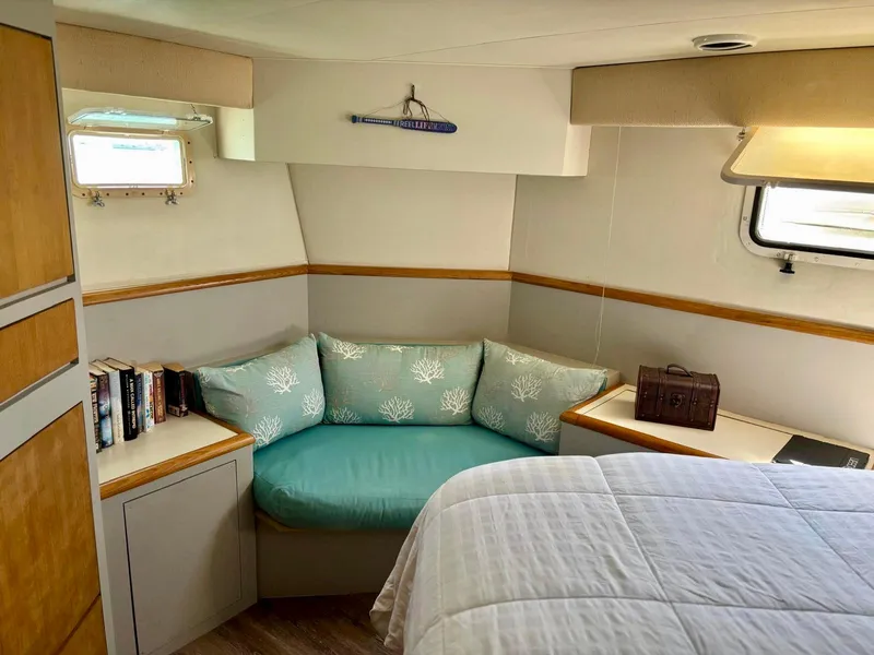 Slide: The Image of Cozy cabin interior of 1991 Hatteras 52 Cockpit Motor Yacht with seating and books. - 23
