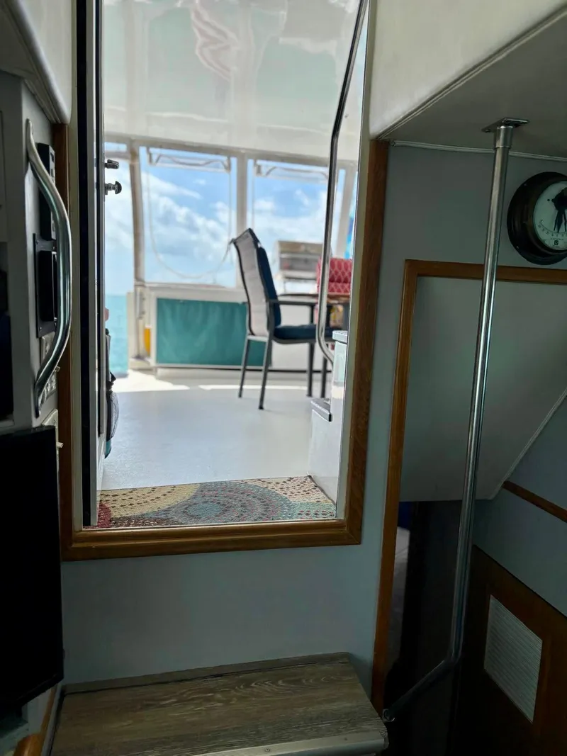 Slide: The Image of Interior view of 1991 Hatteras 52 Cockpit Motor Yacht, showing stairs and seating area. - 35