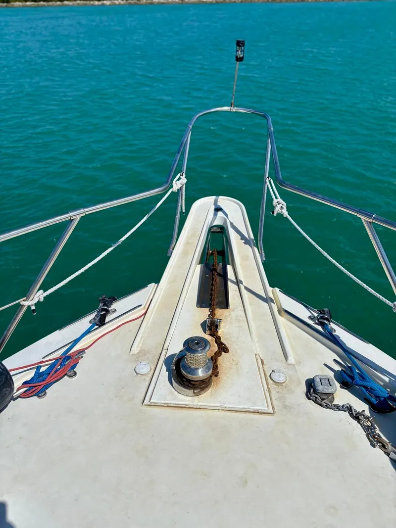 Slide: The Image of Bow view of 1991 Hatteras 52 Cockpit Motor Yacht on turquoise water. - 38