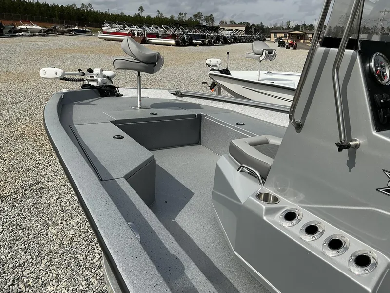 Slide: The Image of 2025 Xpress Hyper-Lift Series H22B boat, gray interior, parked on gravel lot. - 5