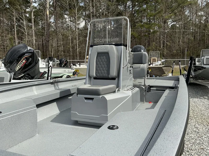 Slide: The Image of 2025 Xpress Hyper-Lift Series H22B boat with seating, parked outdoors. - 7