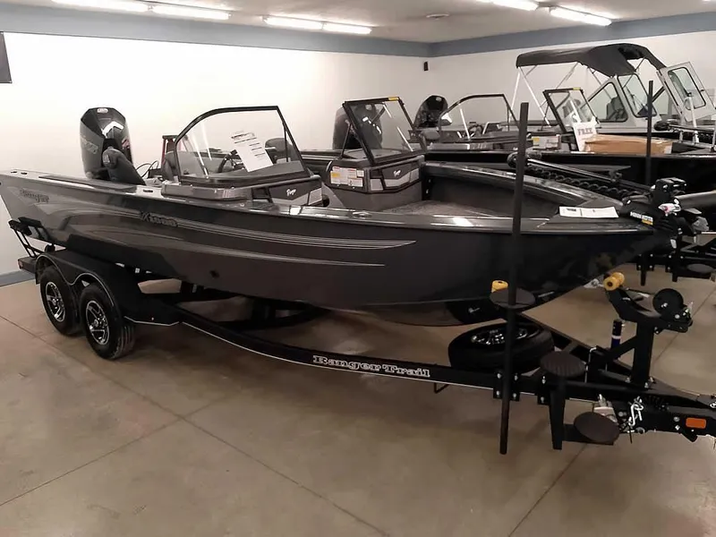 Slide: The Image of 2025 Ranger VX1988 WT boat displayed in showroom, sleek design, dual-axle trailer. - 43