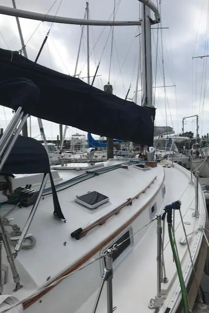 Slide: The Image of 1988 Nonsuch 33 sailboat docked at a marina under cloudy skies. - 11