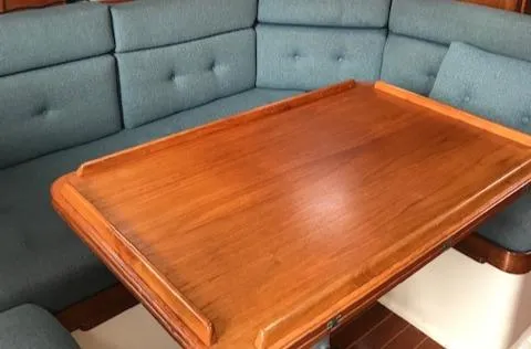 Slide: The Image of Interior of 1988 Nonsuch 33 sailboat with wooden table and blue cushioned seating. - 15