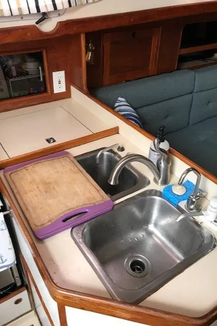 Slide: The Image of 1988 Nonsuch 33 yacht kitchen with dual sinks and cutting board. - 22