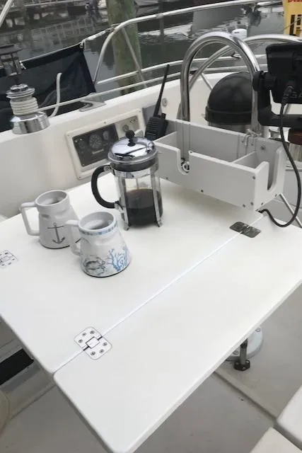 Slide: The Image of 1988 Nonsuch 33 sailboat cockpit with coffee setup, featuring a French press and nautical-themed mugs. - 31