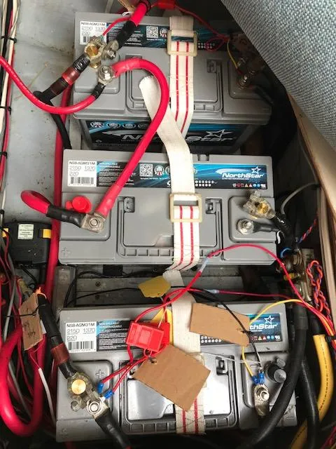 Slide: The Image of Battery compartment of a 1988 Nonsuch 33 sailboat with multiple connected marine batteries. - 35