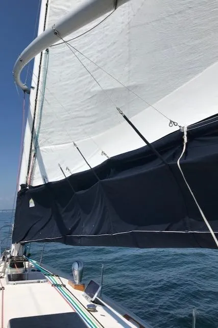 Slide: The Image of 1988 Nonsuch 33 sailboat with sails unfurled on a clear day. - 8