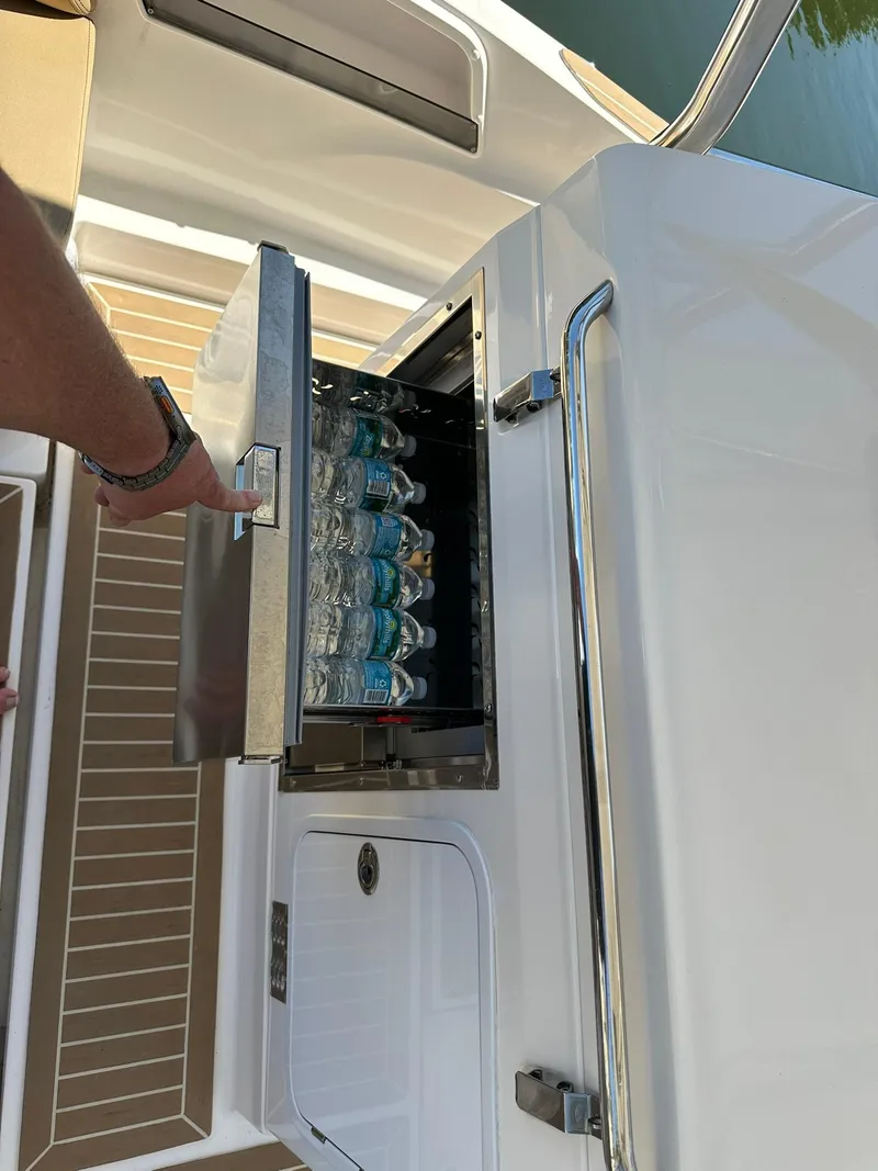 Slide: The Image of Built-in cooler on 2022 Zar Formenti 95 SL boat, stocked with water bottles. - 13