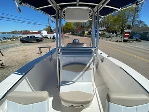 Slide: The Image of 2018 Robalo R200 Center Console boat with seating, docked near a coastal road. - 14