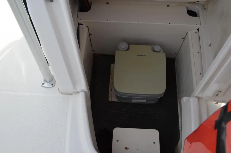 Slide: The Image of 2018 Robalo R200 Center Console boat interior with portable toilet. - 18