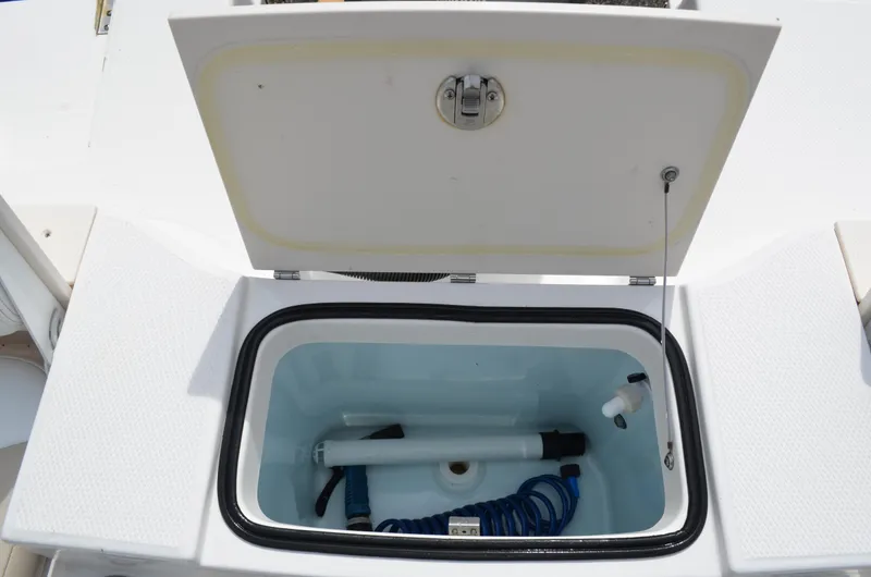 Slide: The Image of 2018 Robalo R200 Center Console storage compartment with open lid and equipment inside. - 22