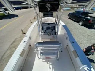 Slide: The Image of 2018 Robalo R200 Center Console boat with seating and steering console, parked on gravel. - 26